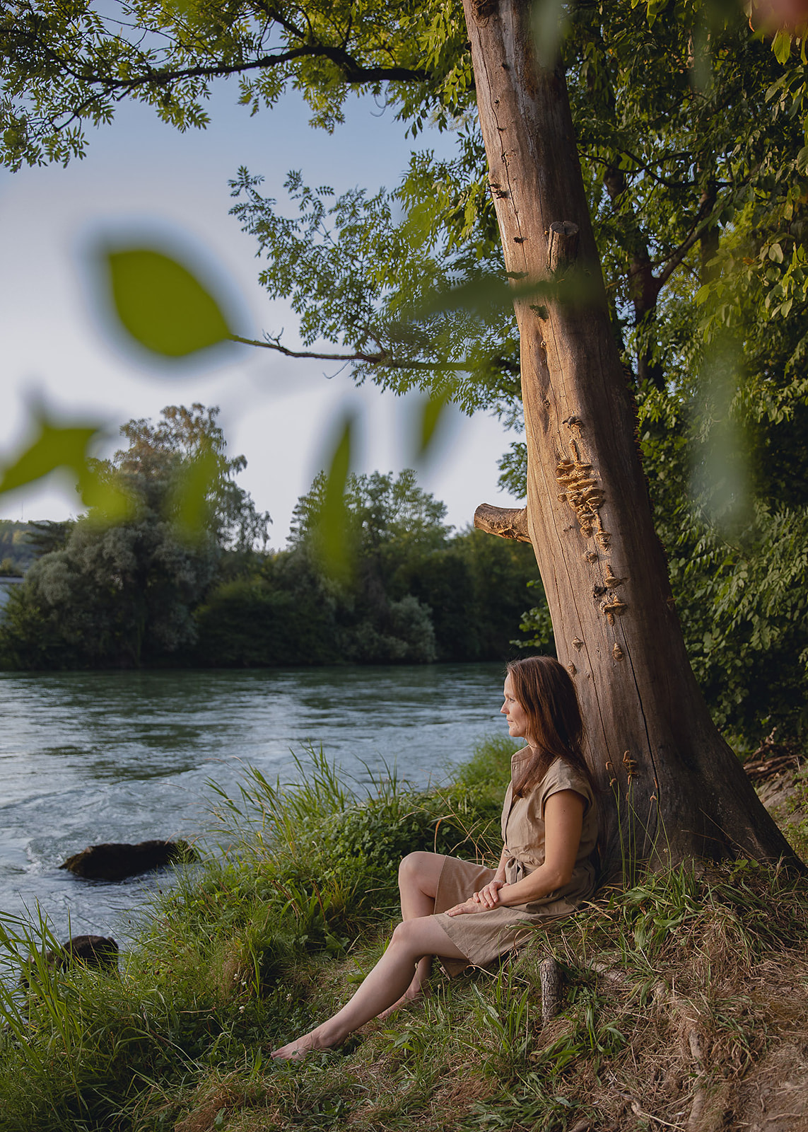 Elvira Christina Wettstein sitzt in der Natur und blickt ruhig in die Kamera.